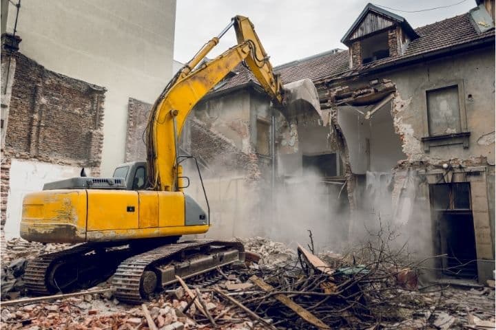 Jefferson County, AL-Building Demolition Bond - A backhoe demolishes a house.