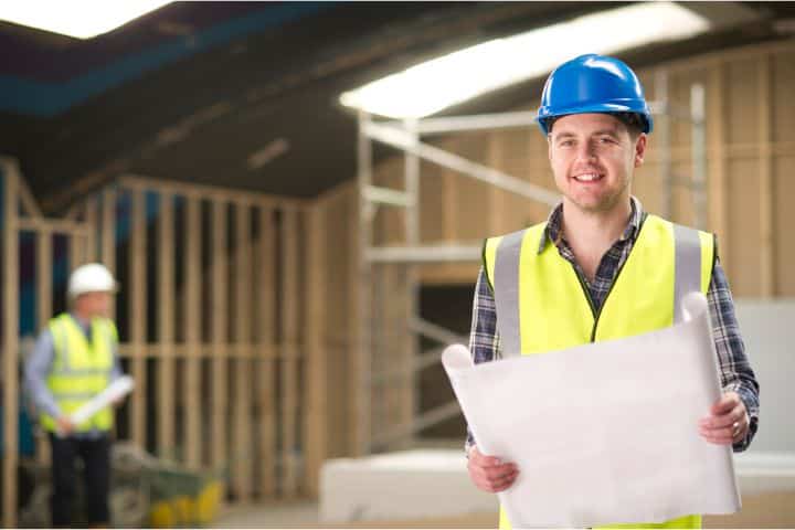 Auburn, AL - General Contractor Bond - A happy general contractor holding his blueprint inside the constructed house.