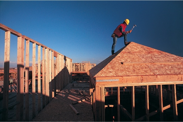 Pasco County, FL - Residential Contractor ($5,000) Bond - A housing construction and at the top of the roof is the worker with hard hat.