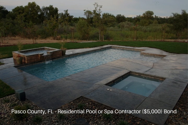 Pasco County, FL - Residential Pool or Spa Contractor ($5,000) Bond - A pool and spa with a decorative spillover surrounded by beautiful landscaping.