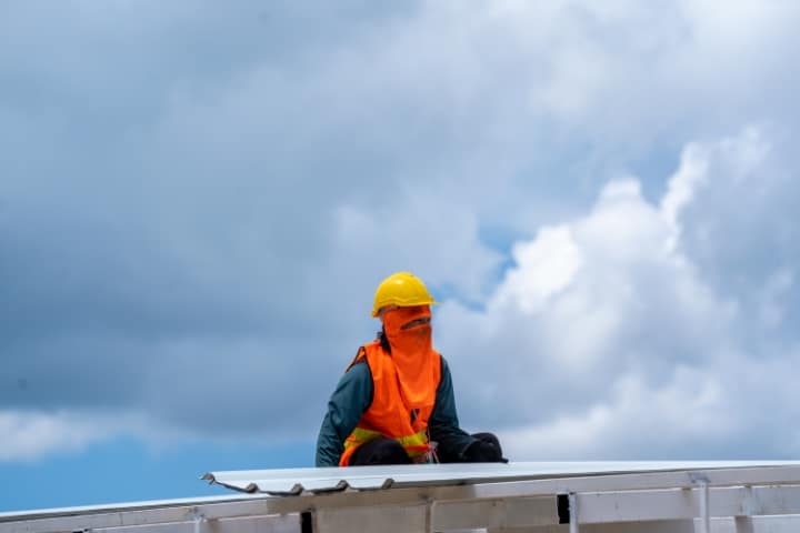 Pasco County, FL - Sheet Metal Contractor ($5,000) Bond - A roofer wearing a hard metal working at metal profile roof installation.