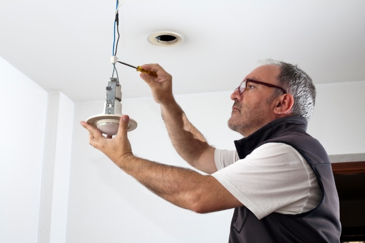 Haines City, FL - Electrician ($5,000) Bond - An electrician working on house light bulb.