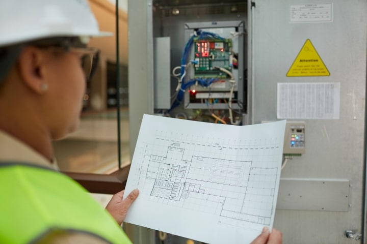 Osceola County, FL - Electrical Contractor License ($5,000) Bond - Female worker inspecting electric system.