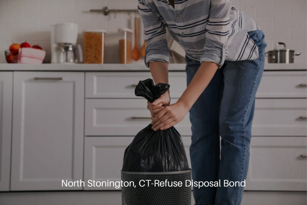 North Stonington, CT-Refuse Disposal Bond - A woman is removing a garbage bag from a bin inside her home.