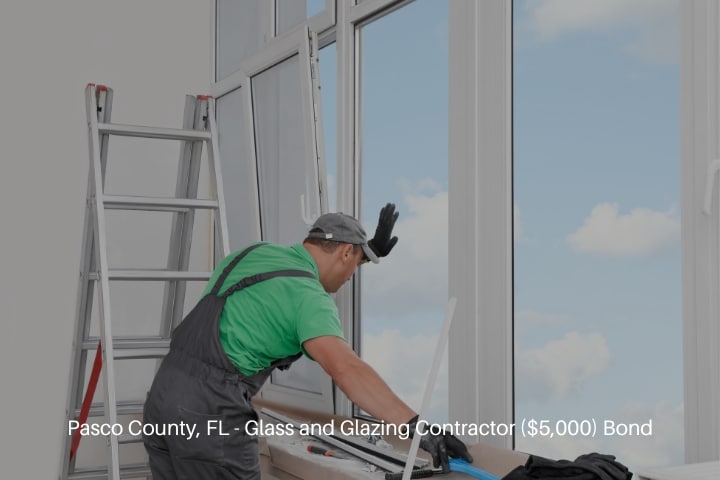 Pasco County, FL - Glass and Glazing Contractor ($5,000) Bond - Worker in uniform installing double glazing window indoors.