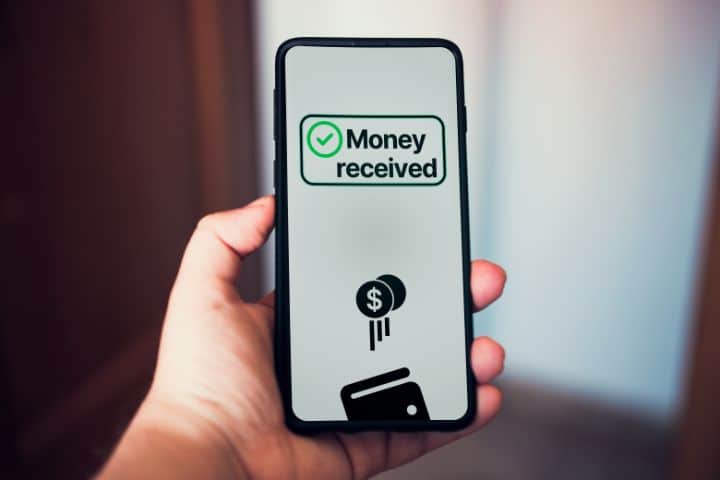 California Money Transmitter Bond - Woman transferring money online using apps on a smartphone.