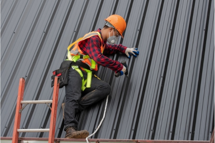 Orange County, FL - Roofing Contractor ($5,000) Bond - Roofer installing metal sheet.