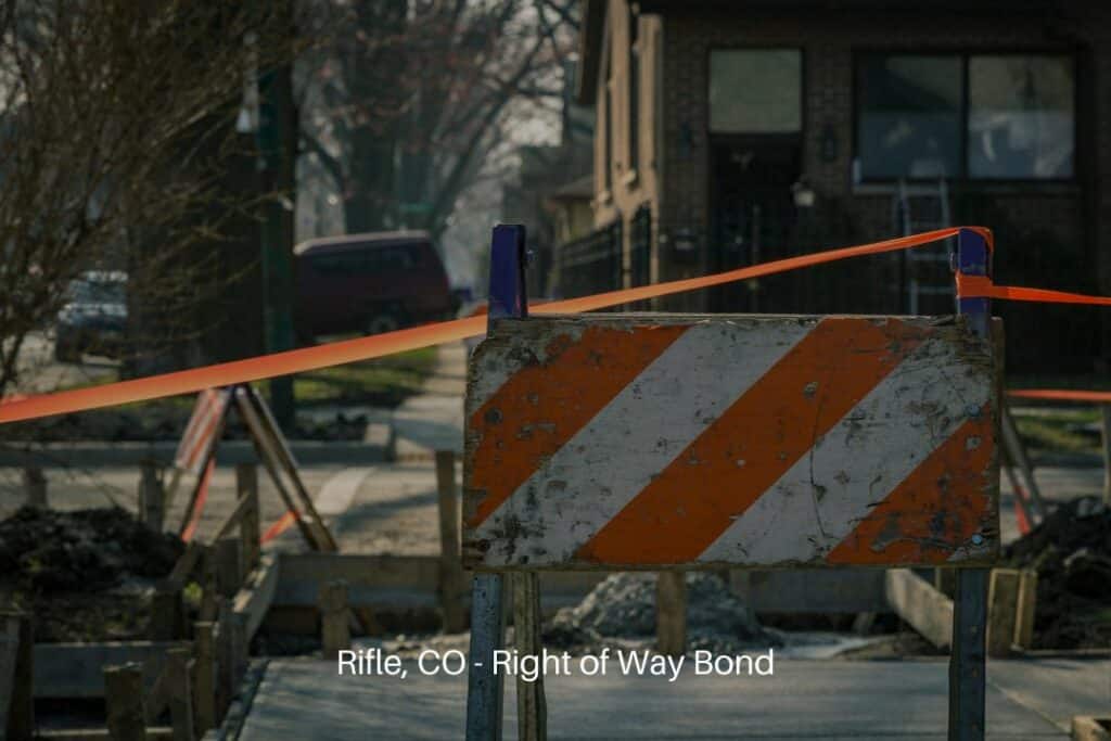 Rifle, CO - Right of Way Bond - Sidewalk closed for construction blocked by orange and white warning sign.