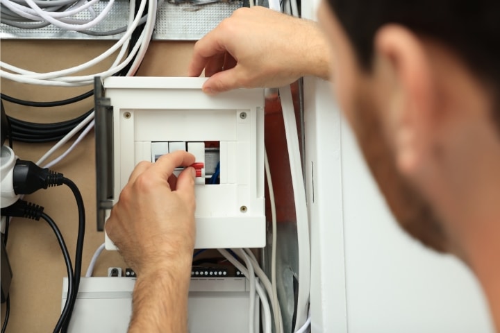 Delaware Master Electrician ($1,000) Bond - Electrician switches off circuit breakers in the fuse box.