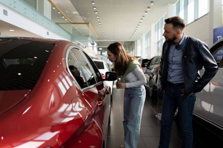 California - Motor Vehicle Dealer ($10,000) Bond - Couple chooses a new car in a showroom car dealership.
