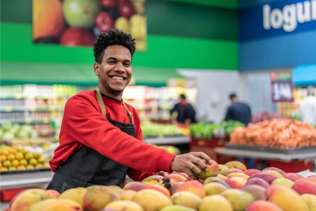 IBEW Local 595 Fringe Benefits Bond - Supermarket worker portrait. Worker arranging the fruits at the supermarket.