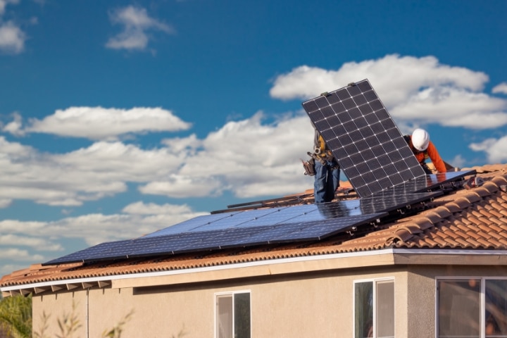 Osceola County, FL - Solar Contractor ($5,000) Bond - Workers installing solar panels on house roof.