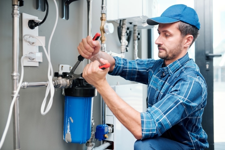 Haines City, FL - Plumber Bond ($5,000) - Young plumber or technician installing or repairing the system of water filtration.