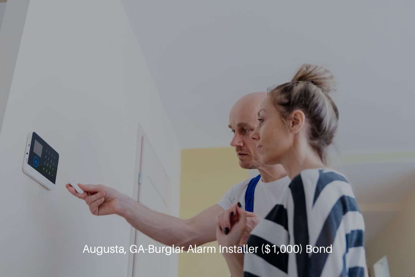 Augusta, GA-Burglar Alarm Installer ($1,000) Bond - An alarm fitter installs an alarm at home. Protection against burglars.