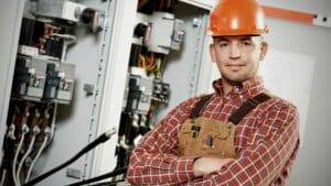Electrician wearing a orange hardhat and checkered polo
