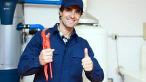 Plumber holding wrench and doing a thumbs up sign