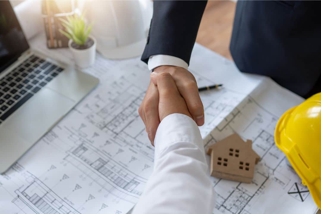 Winter Park, FL - Contractor License Bond - Handshake of engineer with finance investor as meeting and looking at the project blueprint.