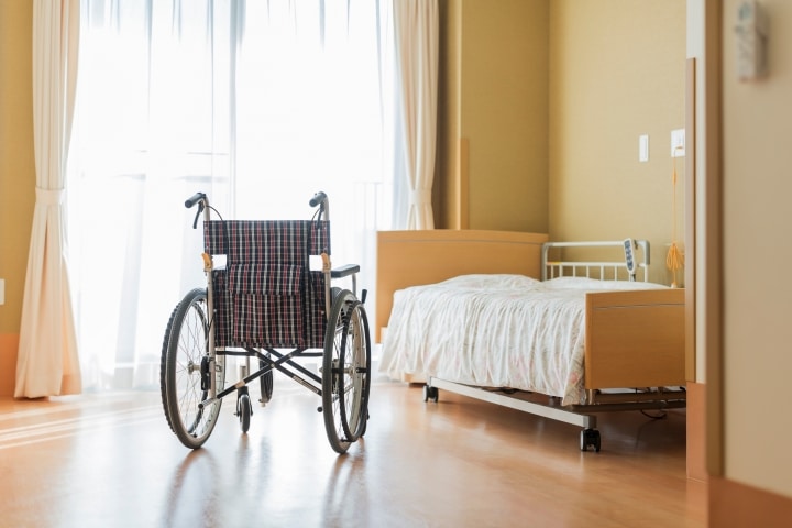FL - Leased Nursing Home Bond - Inside the lease nursing home. Wheelchair and a bed near the window.