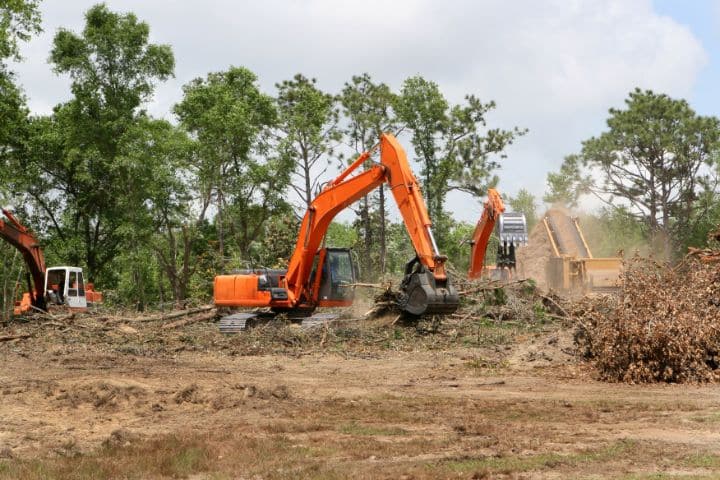 A backhoe is clearing land.