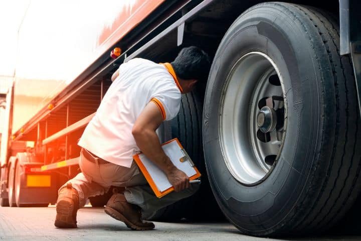 California Motor Vehicle Verifier $5,000 Bond - A truck driver inspecting truck tires.