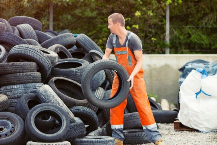 Alabama Scrap Tire Transporter Bond - Recycling worker sorting scrap tires.