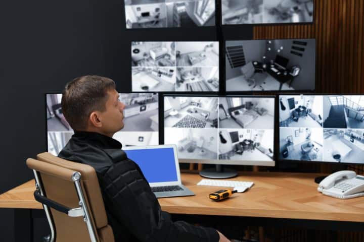 Tuscaloosa, AL-Private Detective and Security Guard Bond ($4,000) - Security guard monitoring modern CCTV camera indoors.