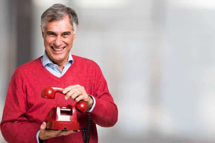California Telephone Corporation $25,000 Bond - A man using a red vintage telephone.