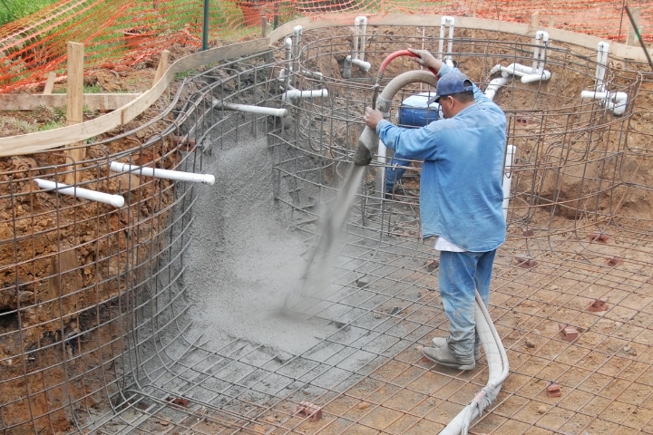 Jacksonville, FL - Pool Contractor ($5,000) Bond - A worker is pouring a concrete to a constructed pool.