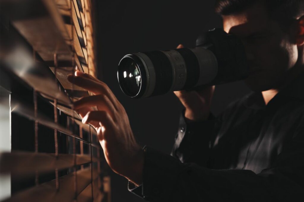 Alamosa, CO - Private Detective $10,000 Bond - Private detective with camera spying near window indoors.