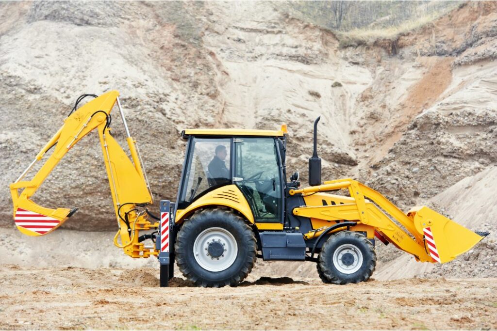 Southington, CT-Excavation Bond - An excavator loader with backhoe works on an open land area.