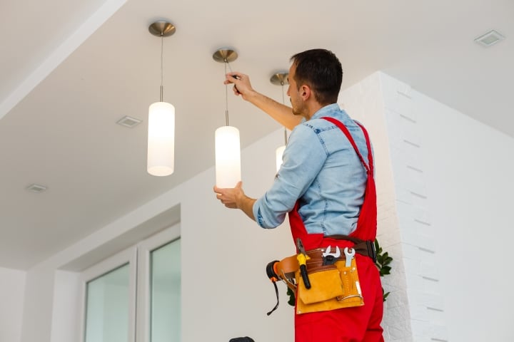 Connecticut Installation Made Easy Inc (IME) IME Affiliate Bond - Electrician man worker installing ceiling lamp.