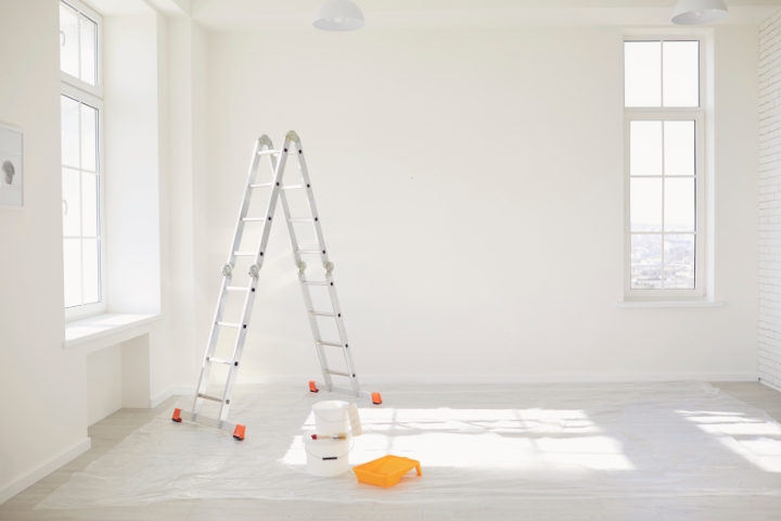 Newark, DE - Minor Renovation Contractor Bond - Painting in a white room with windows with a stepladder.