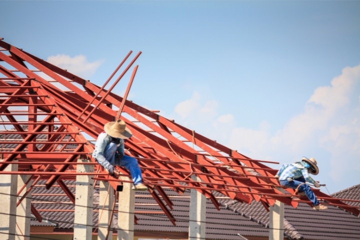 Palm Beach County, FL - Structural Steel ($10,000) Bond - Workers installing steel frame structure of the house roof.