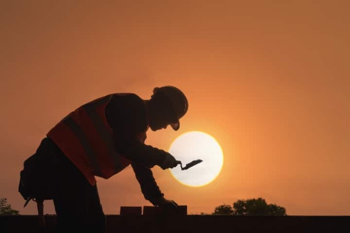 Dundee Township, FL - Contractor's License and Permit ($5,000) Bond - Construction worker at sunset.