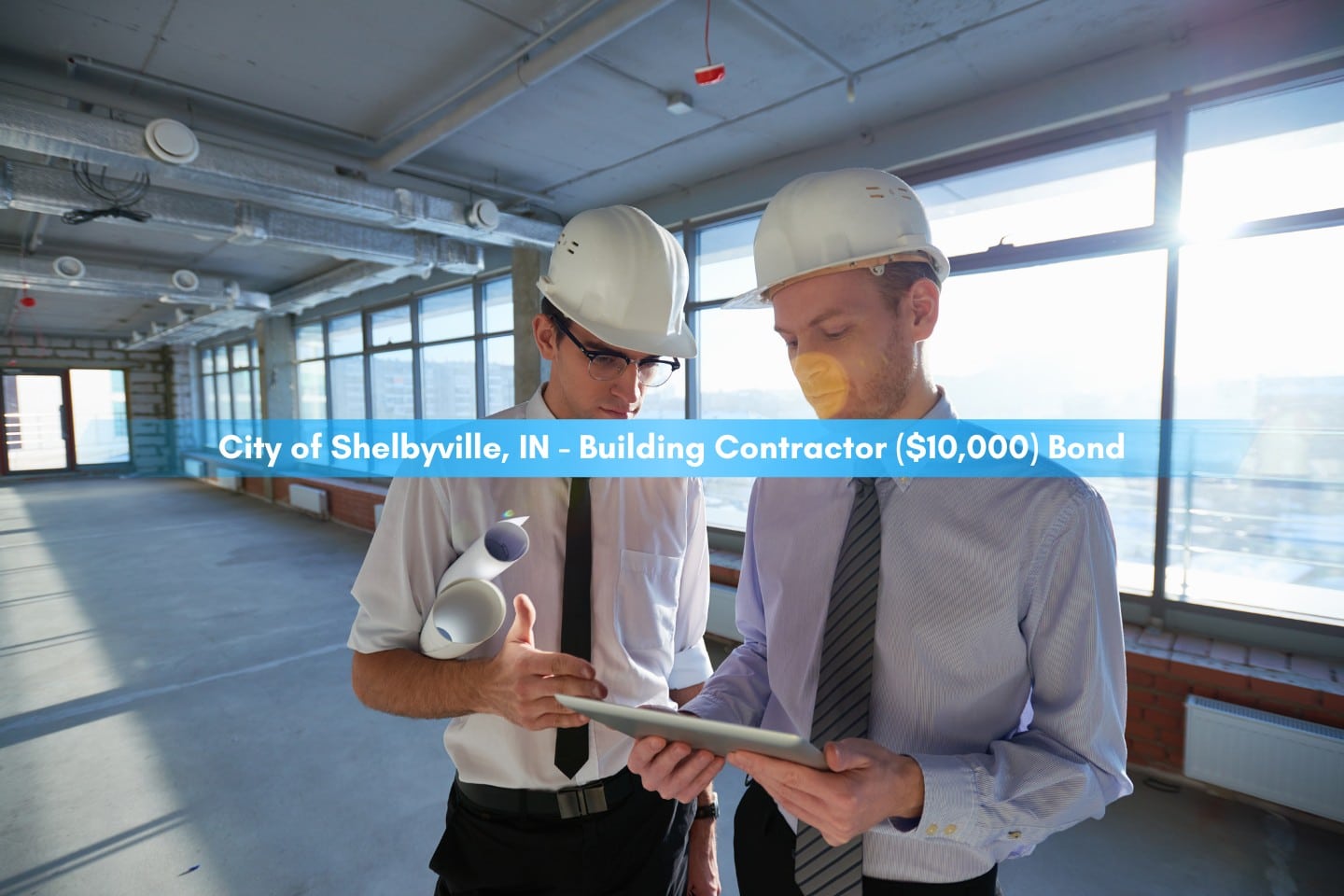 City of Shelbyville, IN - Building Contractor ($10,000) Bond - Two building contractors in hardhats looking at project on tablet.