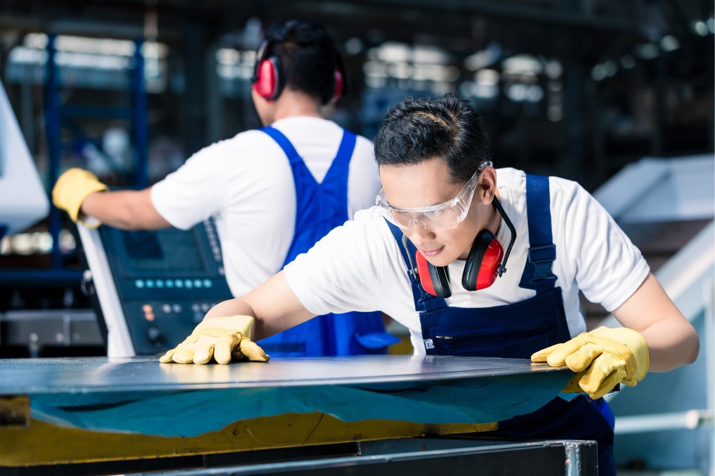 Team of workers with metal sheets at cutter factory.