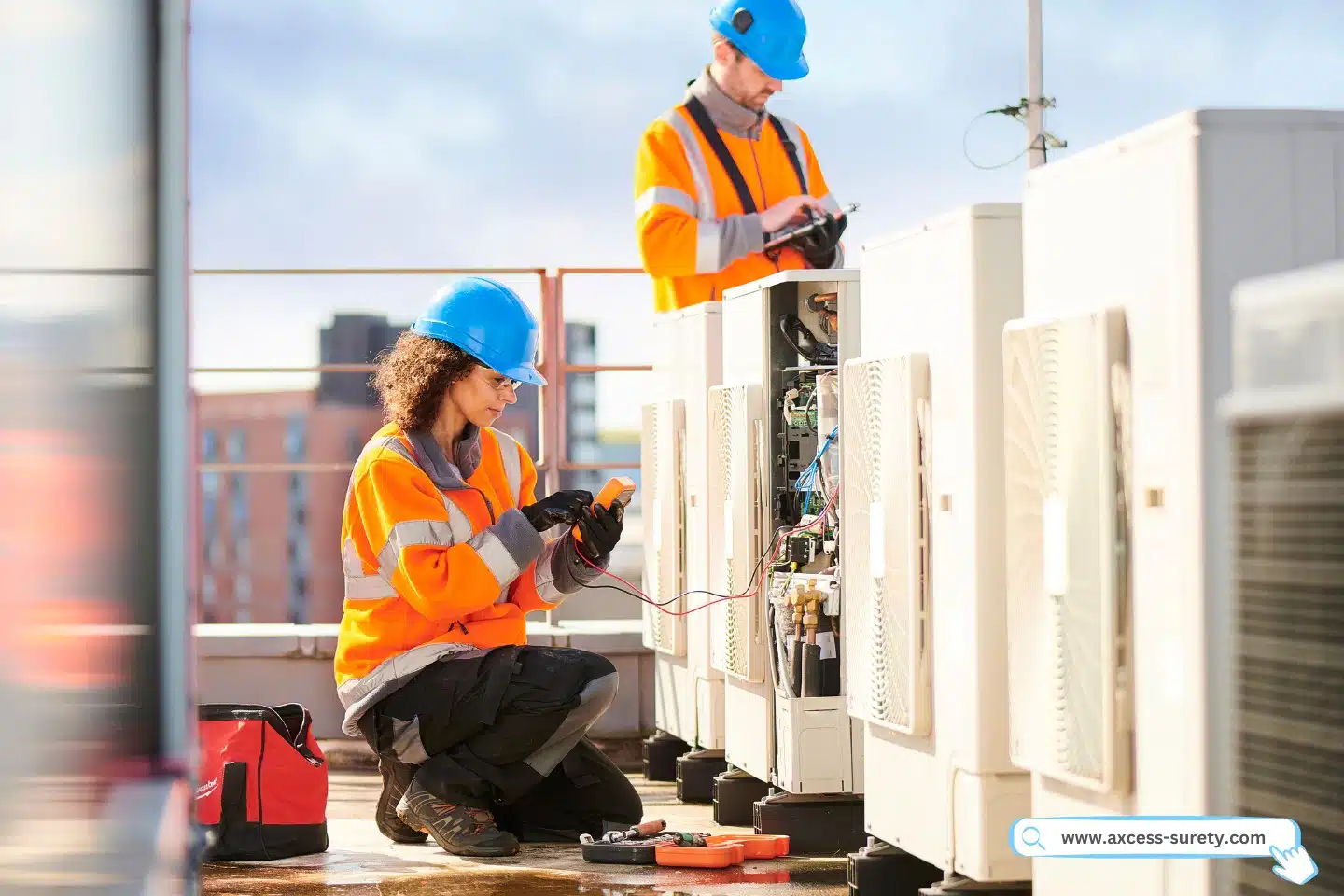 Female and male electrician fixing aircon unit at the rooftop.