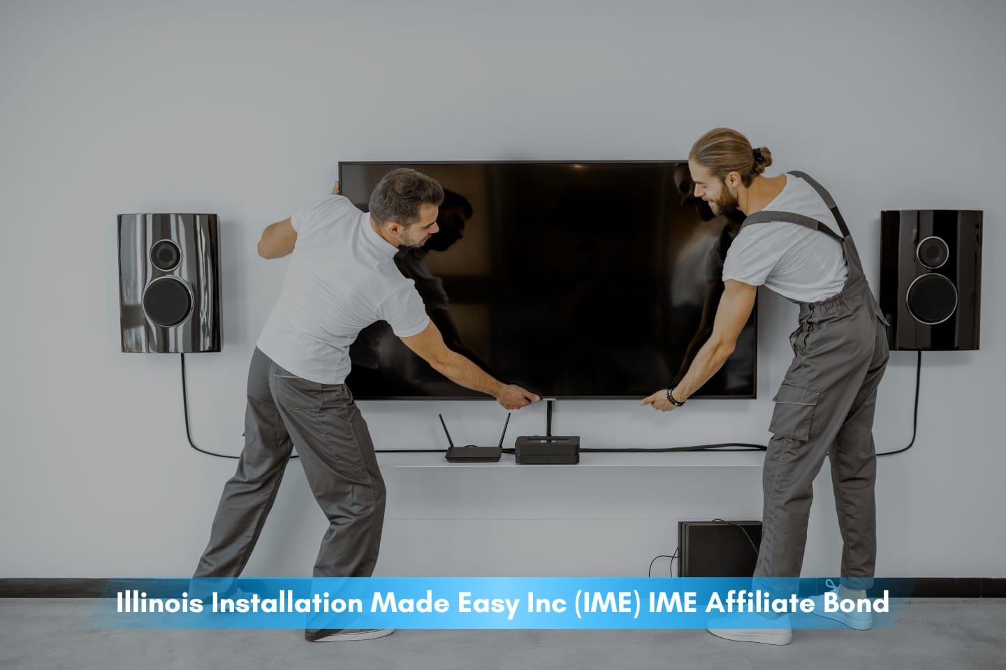 Illinois Installation Made Easy Inc (IME) IME Affiliate Bond - Two professional workmen in workwear installing a large tv monitor and audio system in the living room.