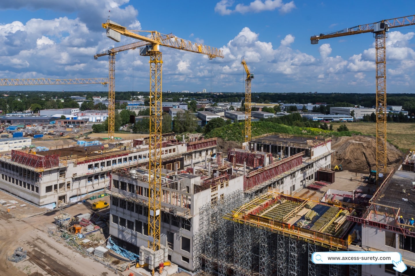Large construction site commercial building construction with multiple cranes and contractors working.