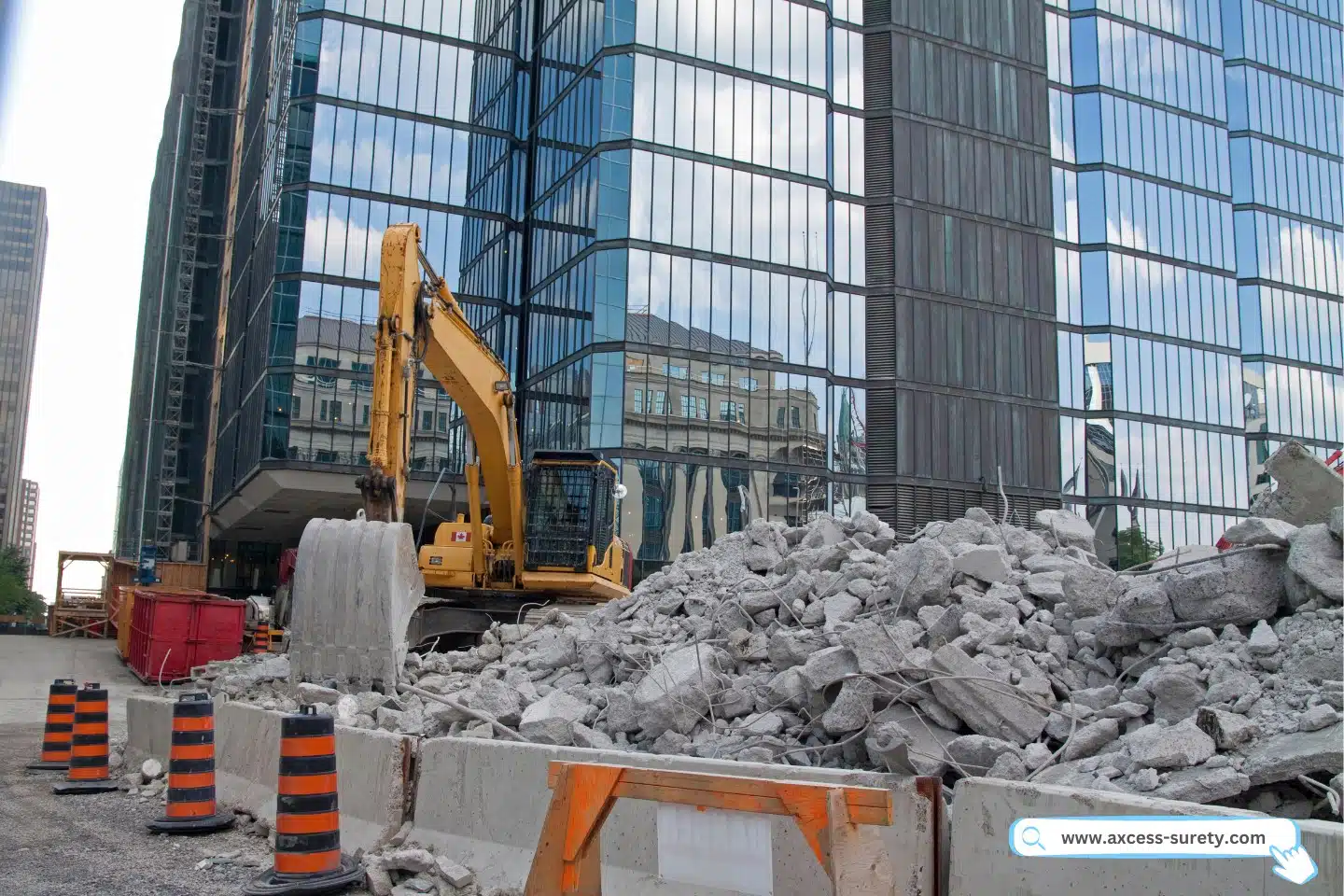 A modern structure with an excavator and a mound of shattered concrete in the back of a downtown location.