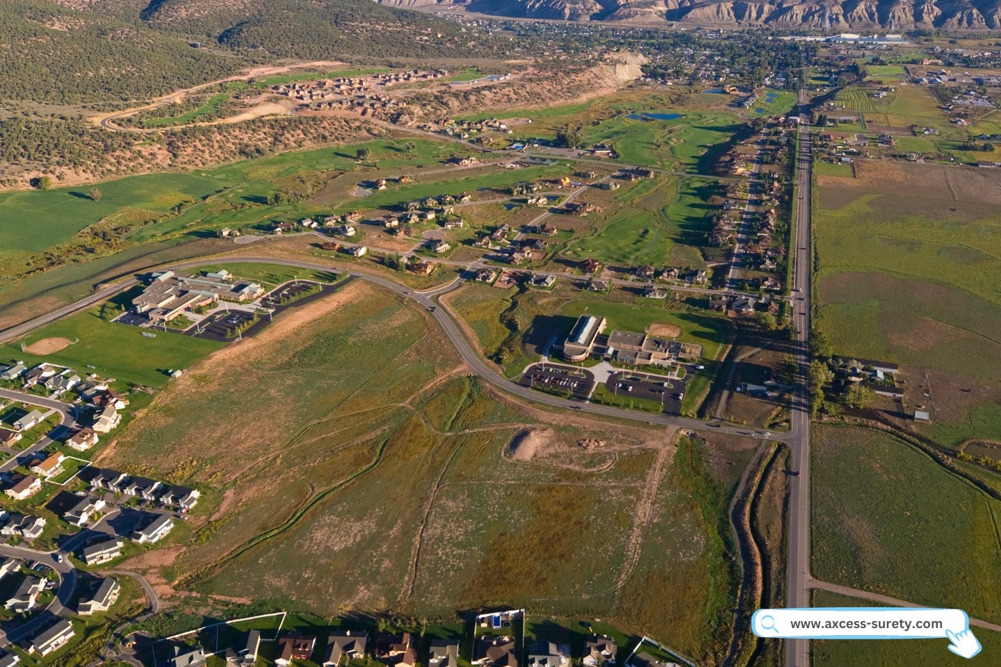 aerial picture of rural countryside being encroached upon by urban expansion along a highway.