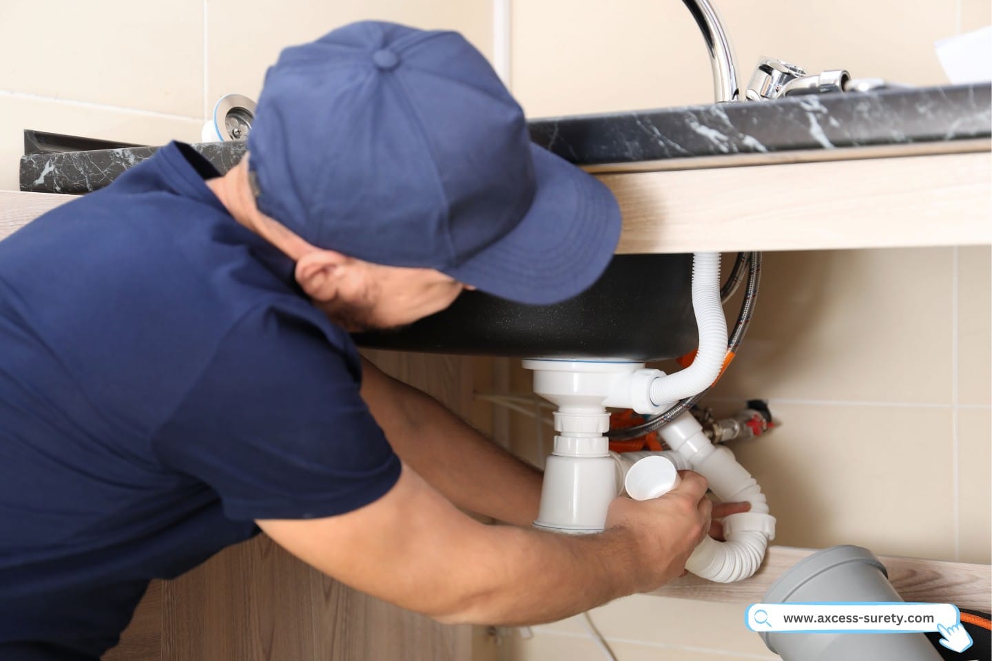 A licensed plumber is changing the sink trap indoors.