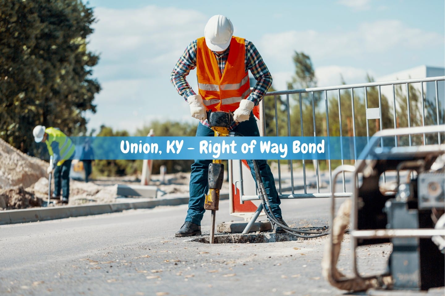 Union, KY - Right of Way Bond - During roadworks, a worker wearing a reflective vest and a drill fixes the street.
