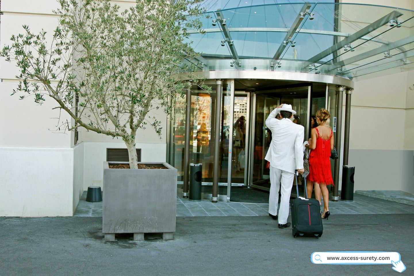 A couple arriving at the hotel entrance with their bags.