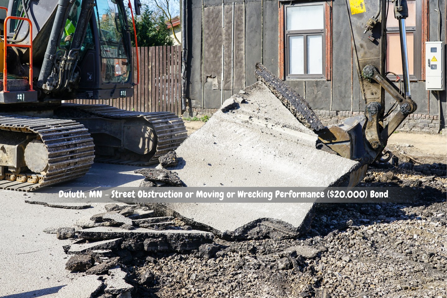 Duluth, MN - Street Obstruction or Moving or Wrecking Performance ($20,000) Bond - Before the city street is rebuilt, the old asphalt layer is removed using a big crawler excavator equipped with a bucket.