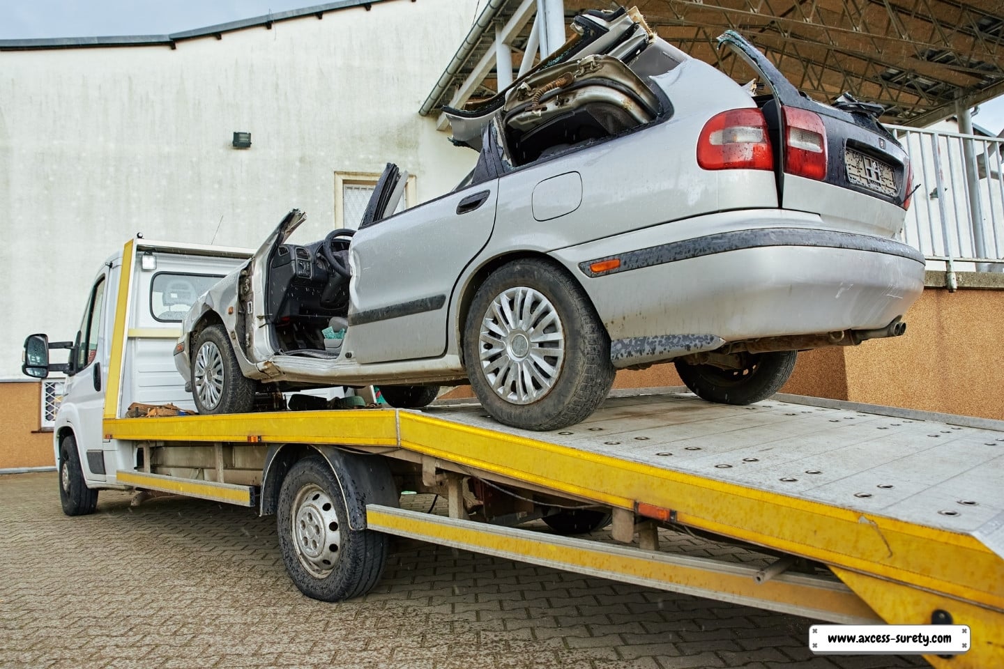 After a highway traffic collision, a car crashed and was loaded into a tow truck.