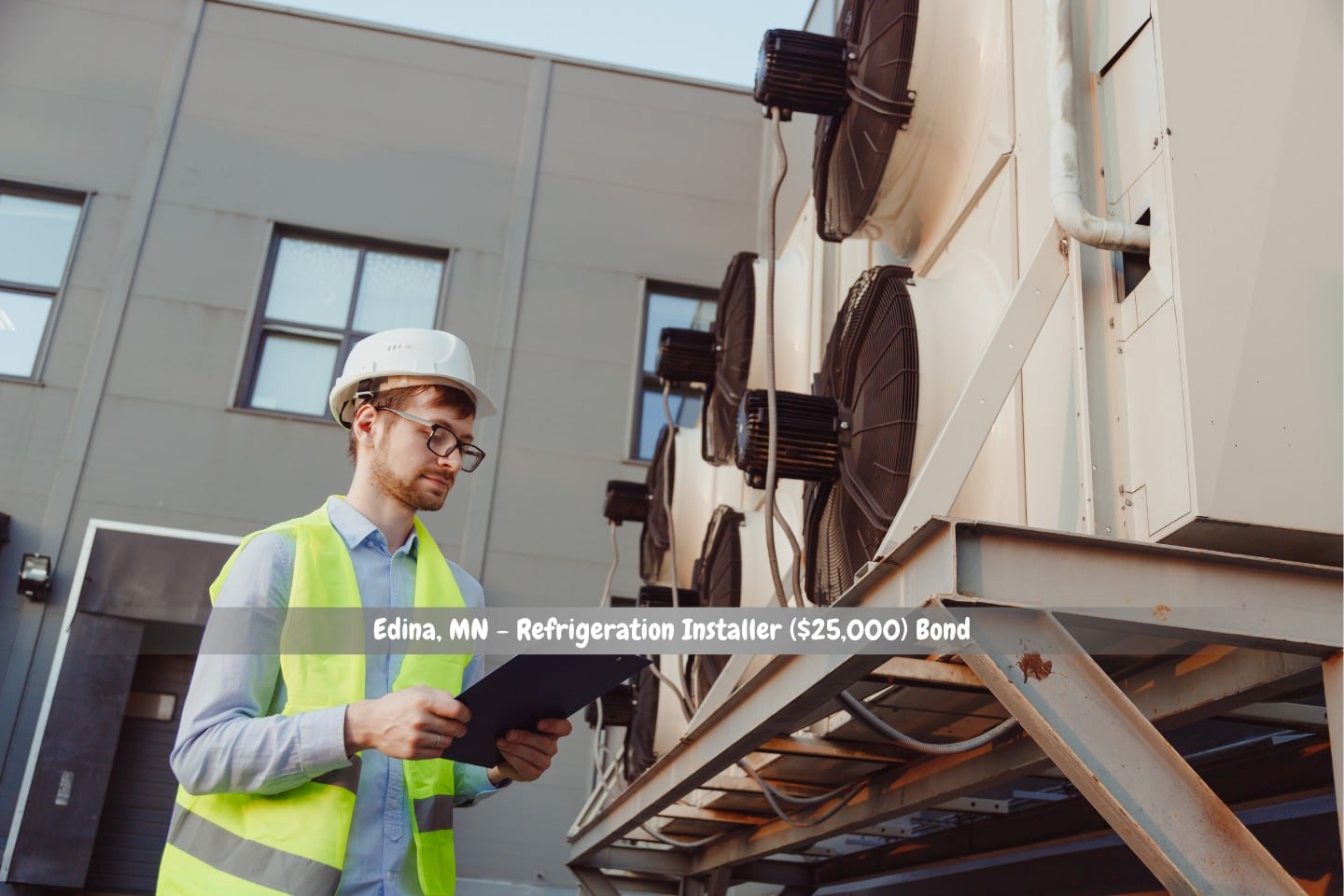Edina, MN - Refrigeration Installer ($25,000) Bond - An industrial refrigeration system is being inspected by a uniformed, hard-hatted service HVAC engineer.