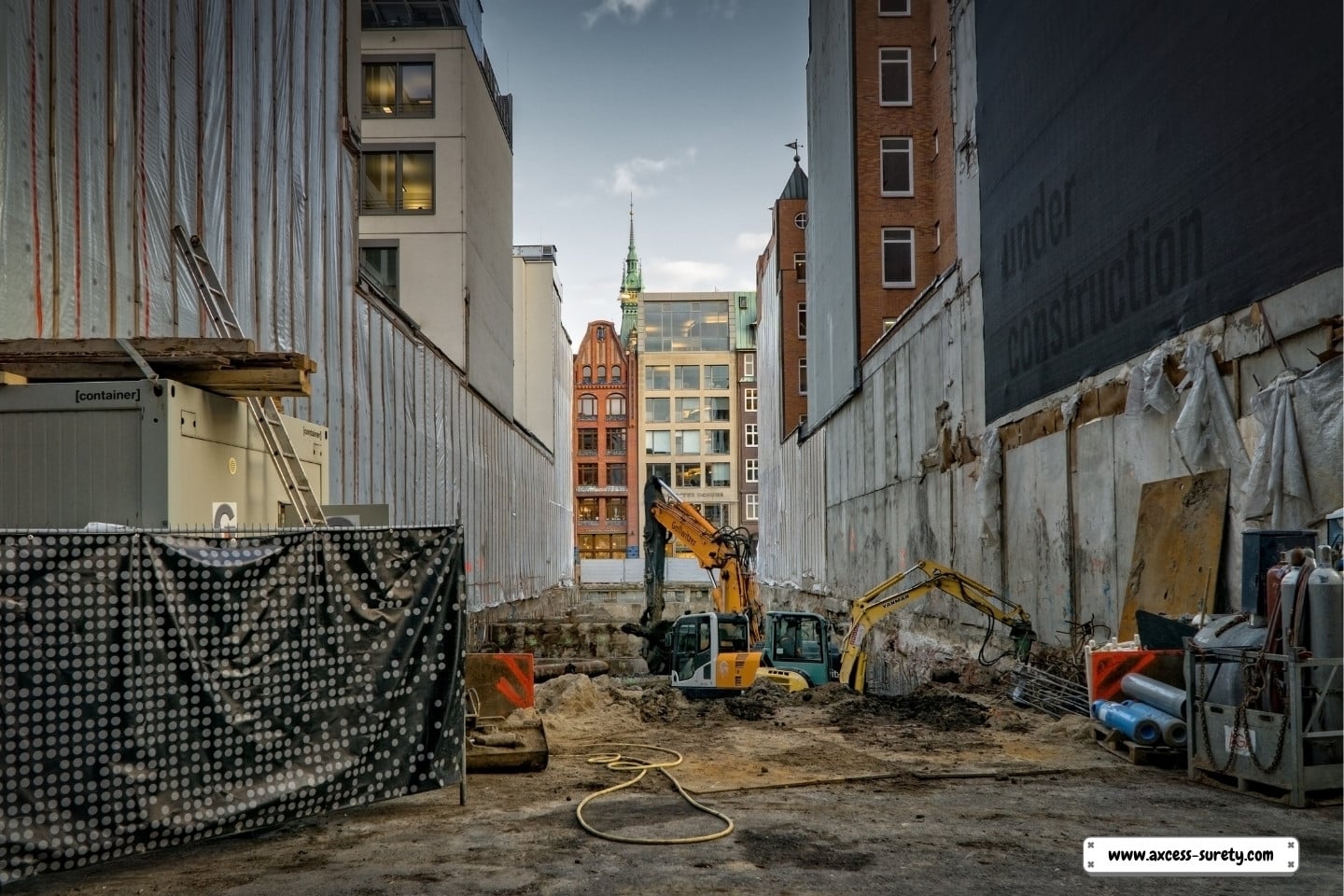 An excavator in yellow and black is working on the new building right next to the road.