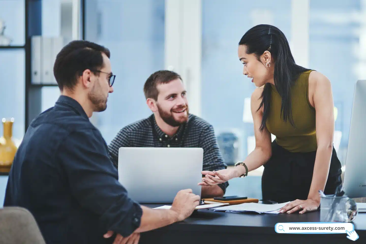 An image shows a bunch of youthful agency workers in an office discussing something.