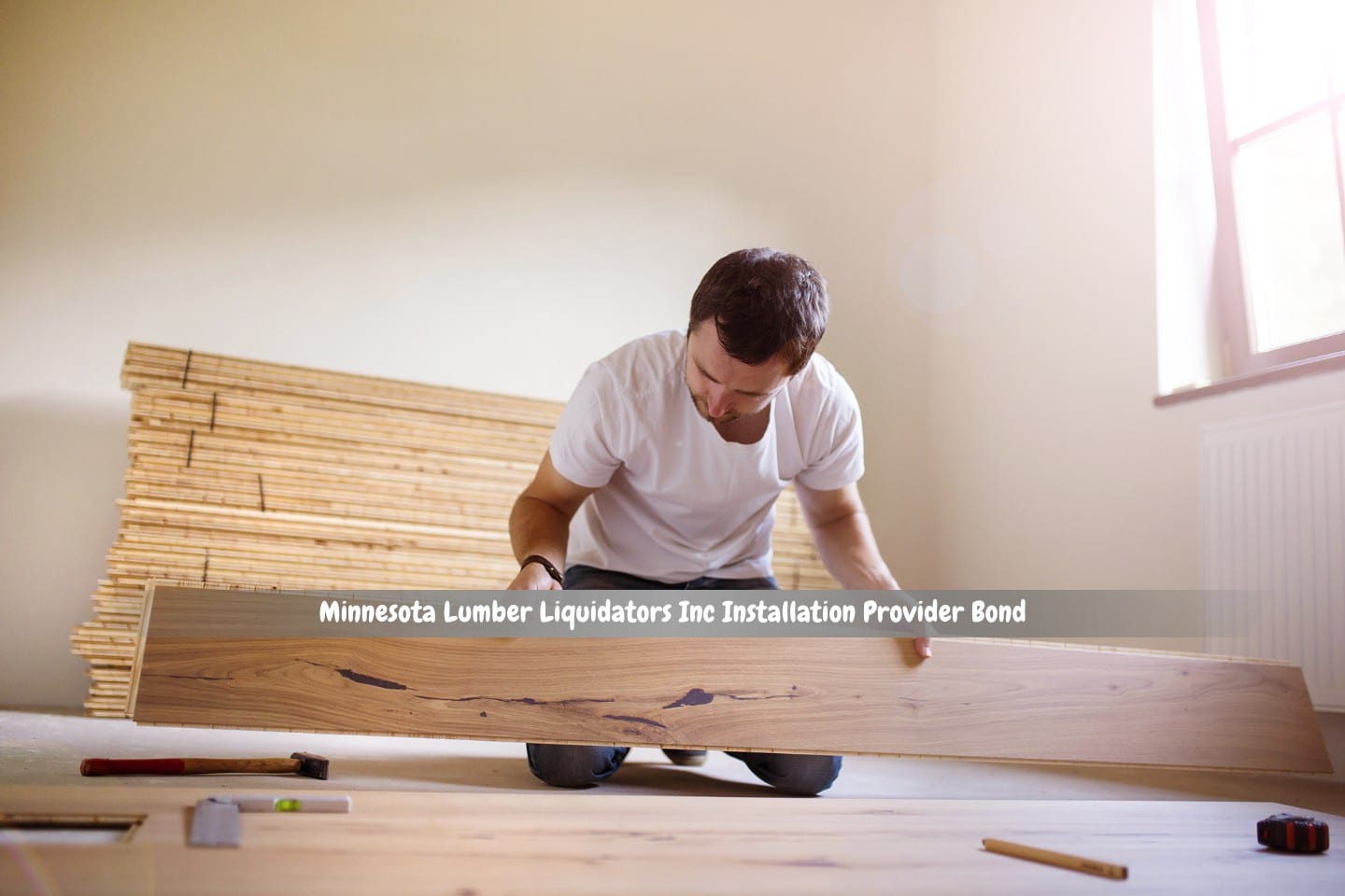 Minnesota Lumber Liquidators Inc Installation Provider Bond - In a new home, a young handyman is laying a wooden floor.
